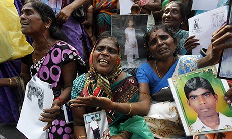 Tamil women hold images of their disappeared relatives